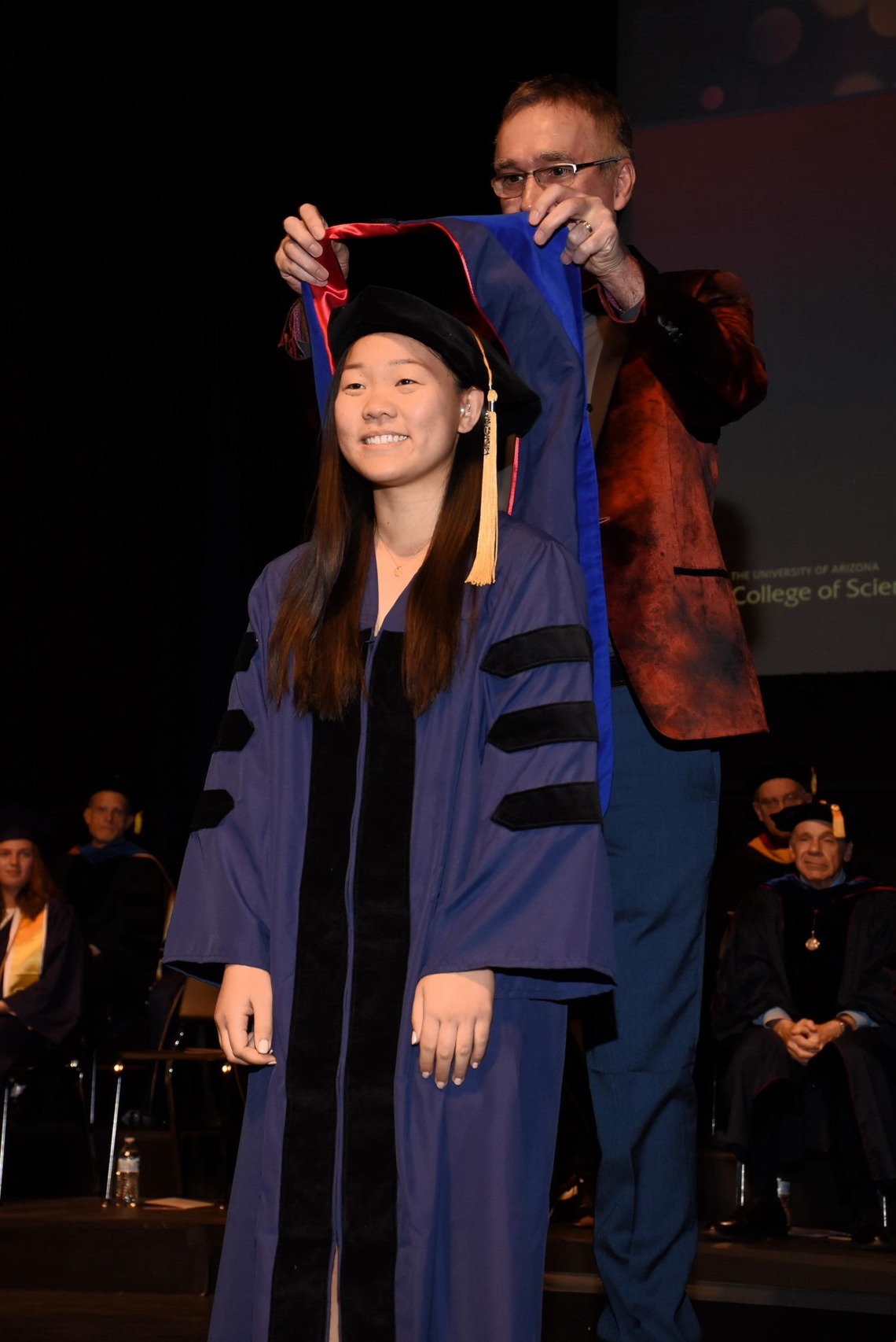 Beverly Feng presented with a PhD graduation garment by Dr. Andrei Sanov