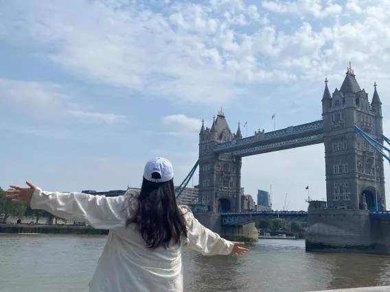 Chloe Park with back to camera facing a bridge with a historic looking building at either end