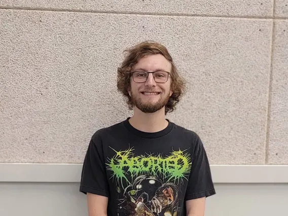 Nick Lauta smiling towards the camera, wearing a black shirt.