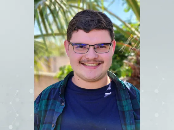 Douglas Swango standing in front of palm trees, smiling towards the camera.