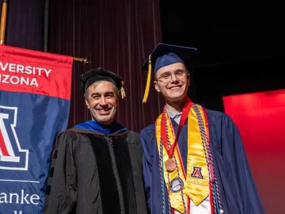 Caleb Seekins on stage with Dean John Pollard during award ceremony for the W.A. Franke Honors College Outstanding Senior award