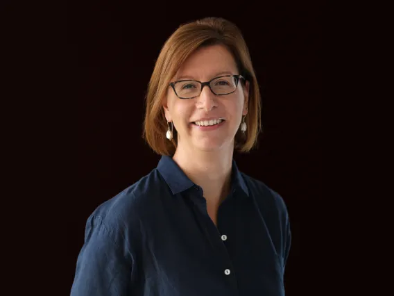 Elisa Tomat standing in front of a black background