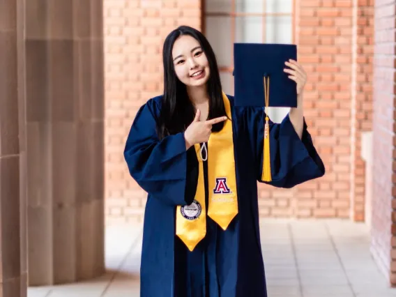 Chloe Park wearing a graduation gown and holding a graduation cap