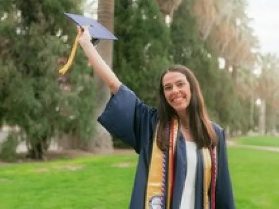 Heather Kwapiszeski in graduation gown holding cap