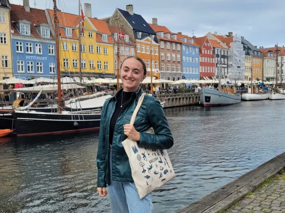 Erin Schuette smiling in front of a river and rows of buildings