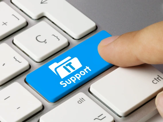 IT Support written on a keyboard button and a persons finger clicking the button