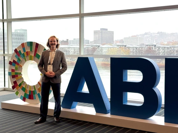 Jake Shaw standing in front of ABRCMS statue in a building