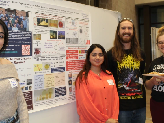 Students and visitors standing in front of research poster