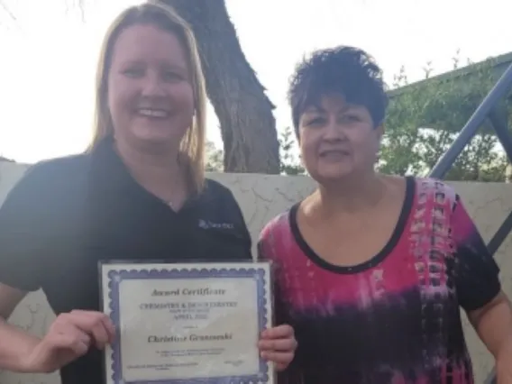 Christine and Olivia smiling with award