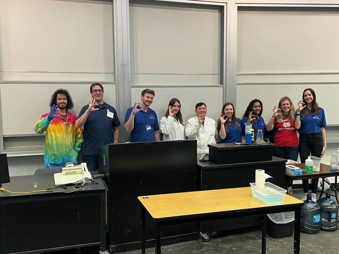 CBC participants hold up the "WC" while on stage during the chemistry magic show