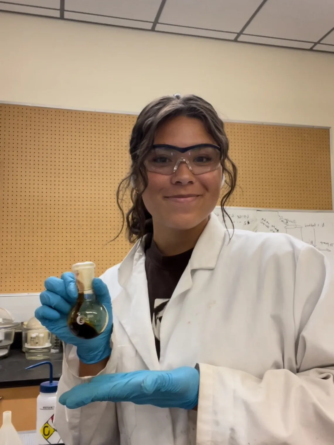 Maddie Tibayan holding a chemical in a vial