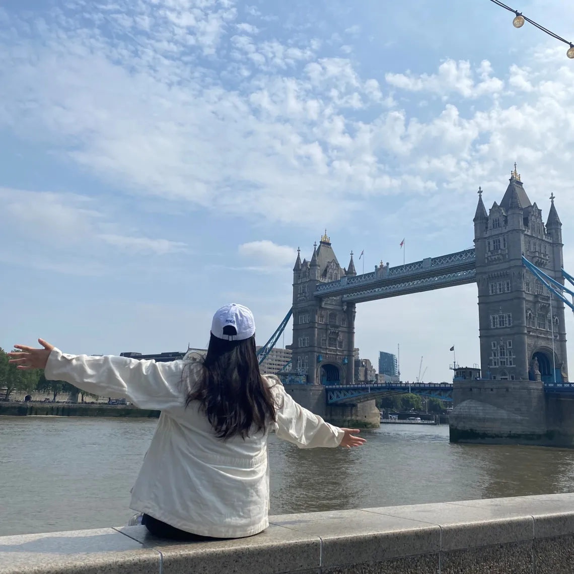 Chloe Park with back to camera facing a bridge with a historic looking building at either end