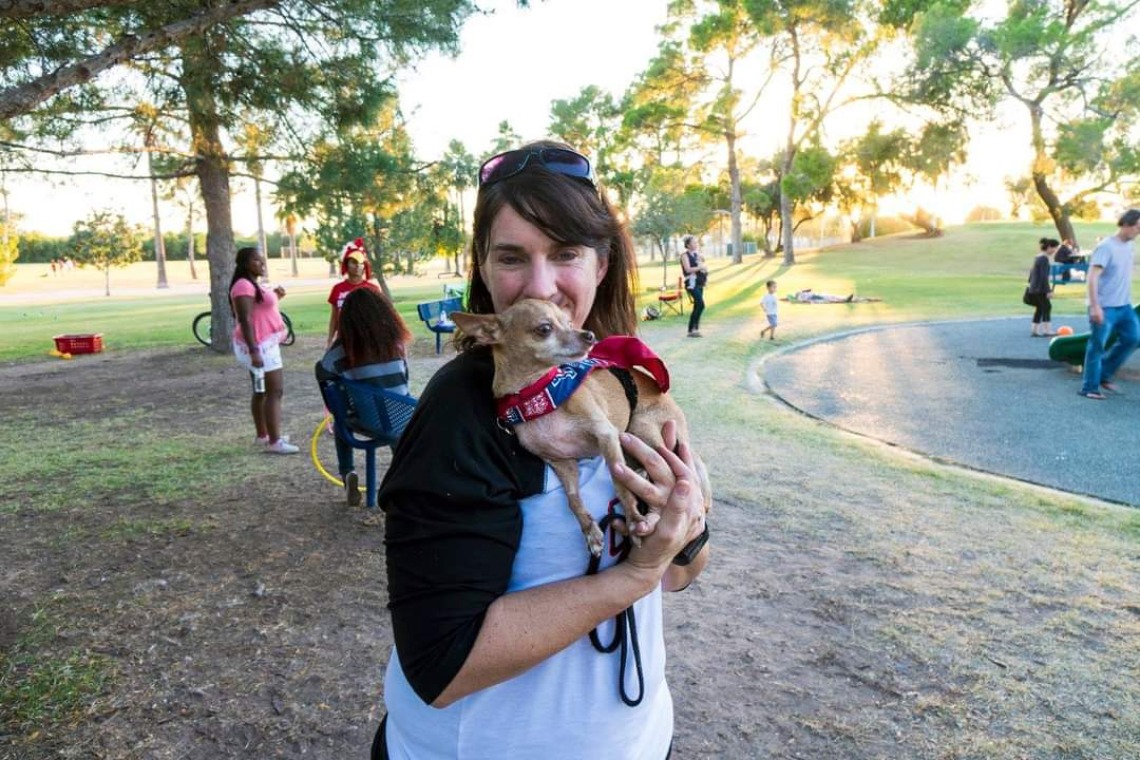 Jennifer Autz holding a small dog in a park