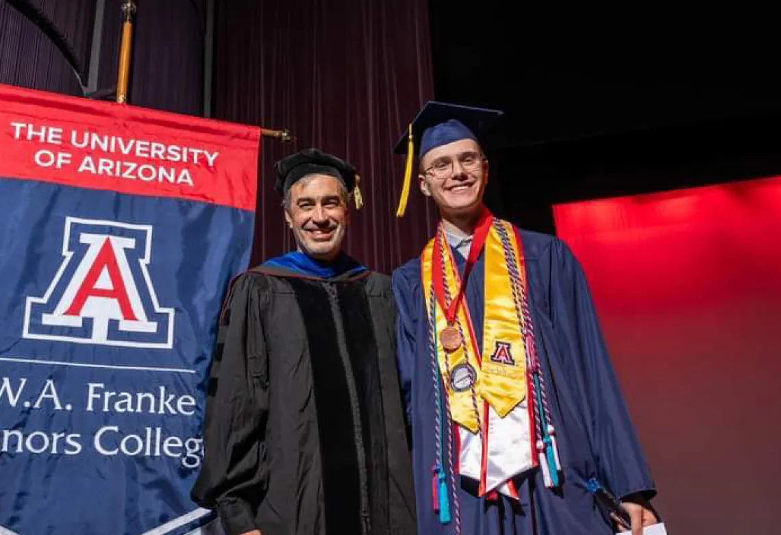 Caleb Seekins on stage with Dean John Pollard during award ceremony for the W.A. Franke Honors College Outstanding Senior award