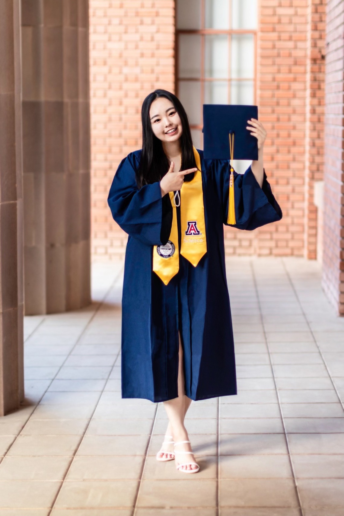 Chloe Park wearing a graduation gown and holding a graduation cap