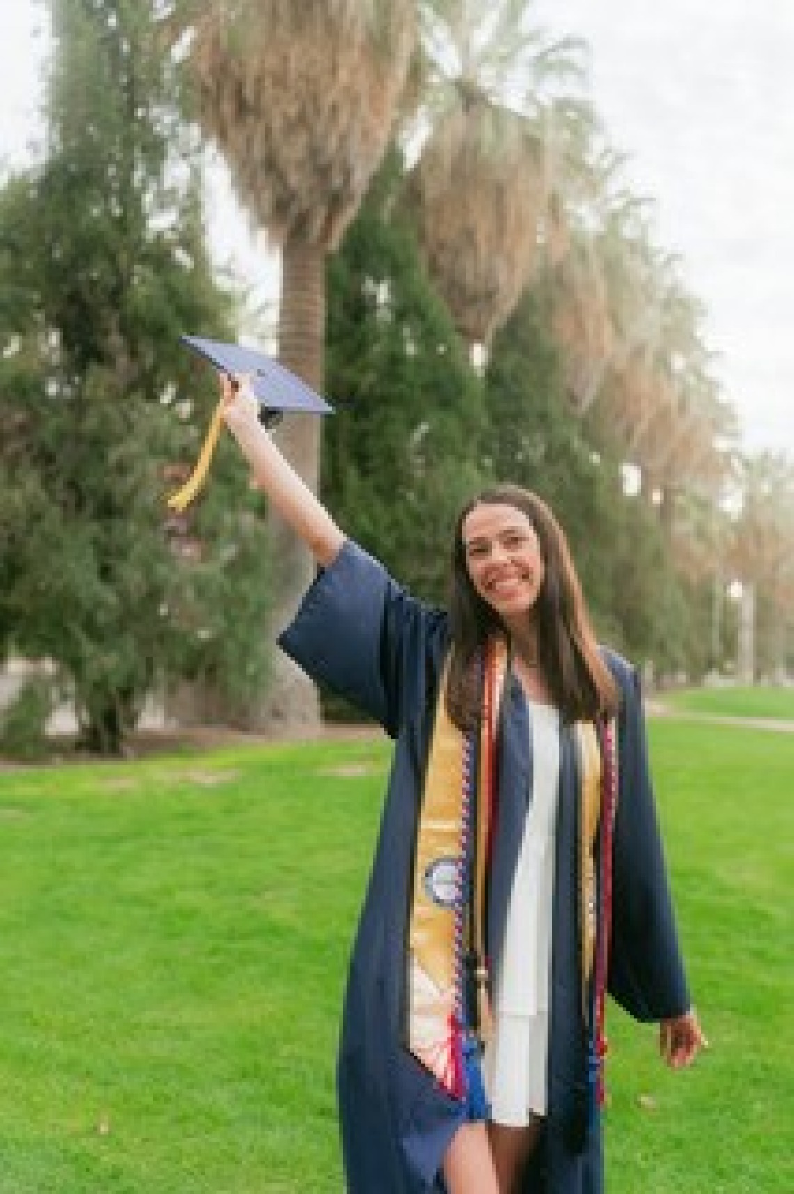 Heather Kwapiszeski in graduation gown holding cap
