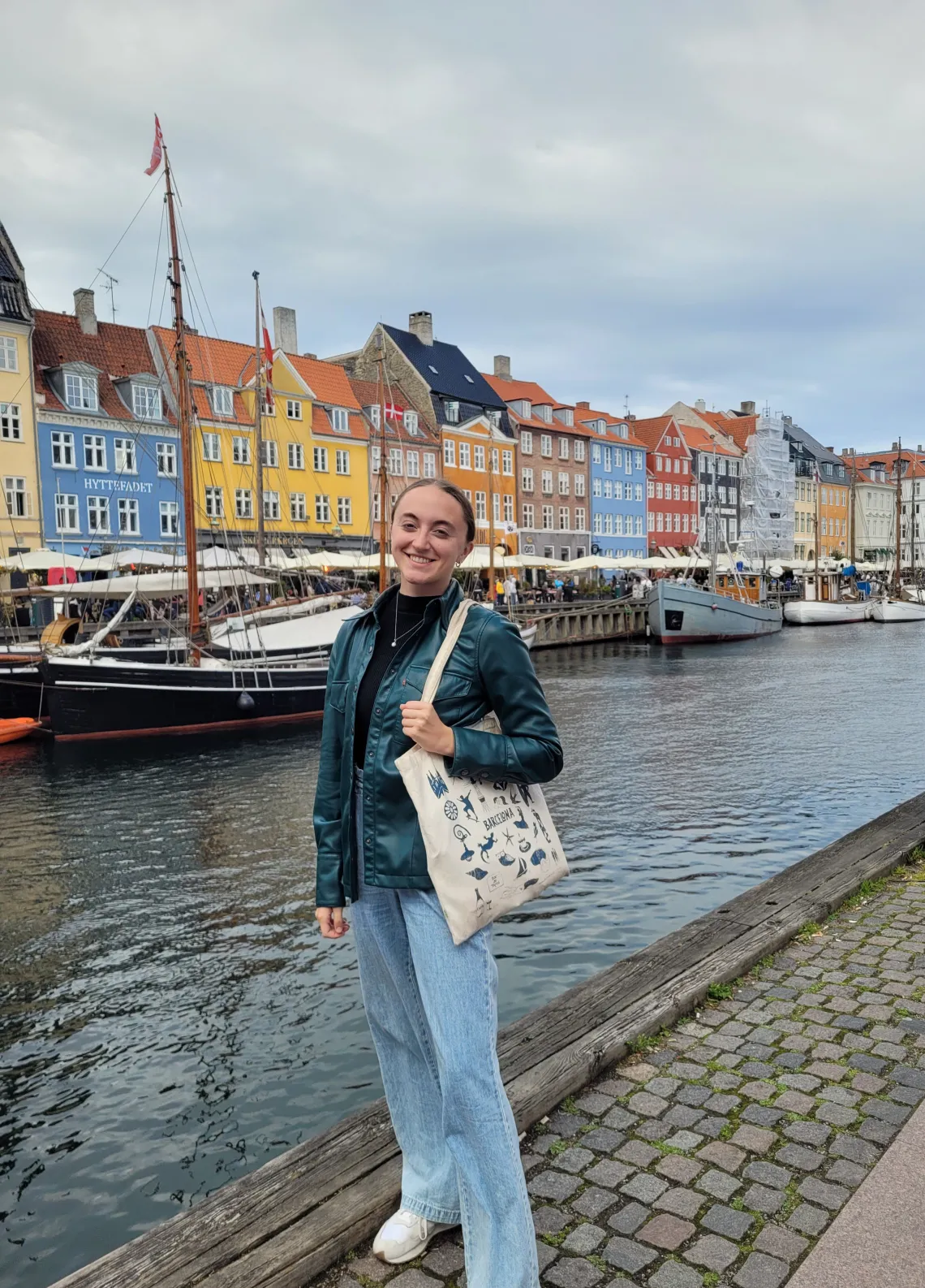 Erin Schuette smiling in front of a river and rows of buildings