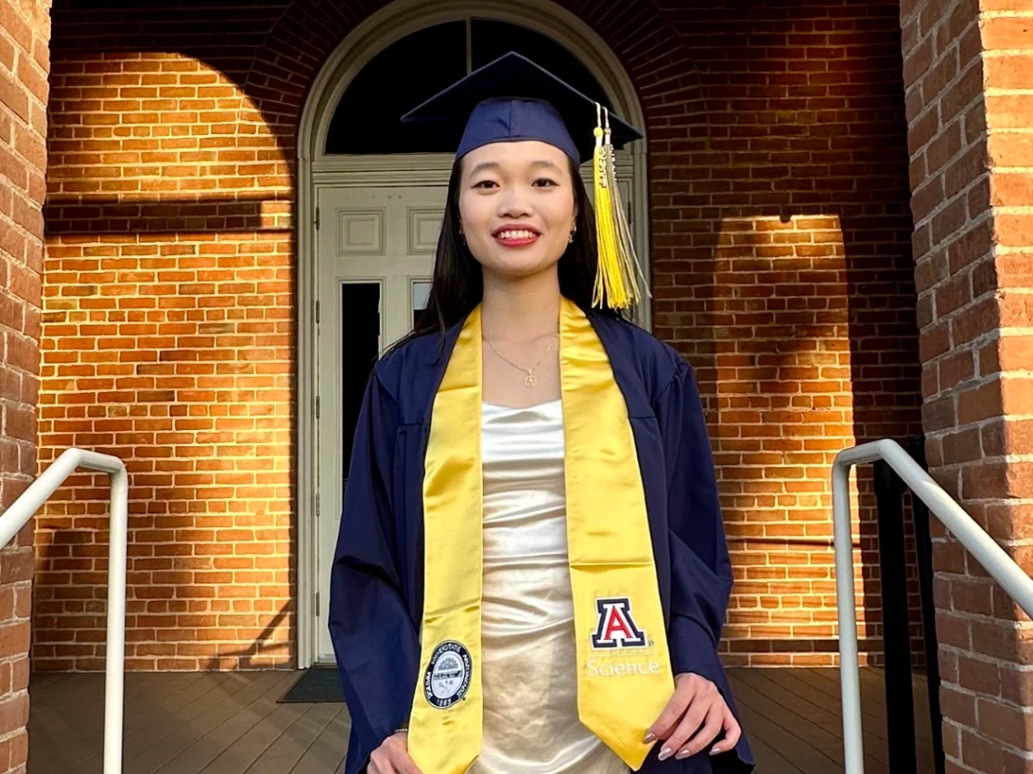 Truc Le wearing graduation cap and gown