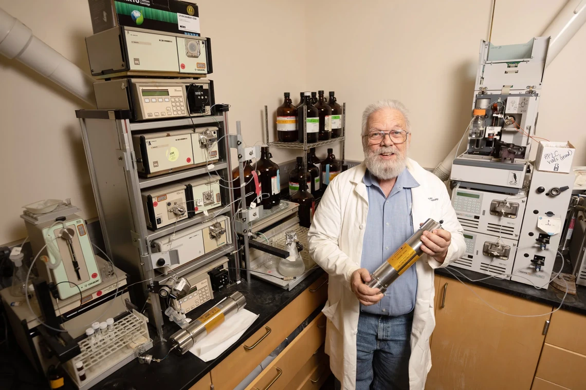 Photo of Dr. Robin Polt in lab holding a canister