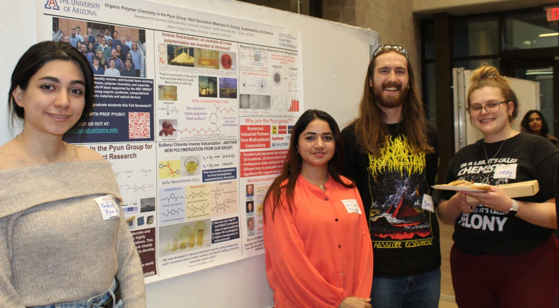 Students and visitors standing in front of research poster