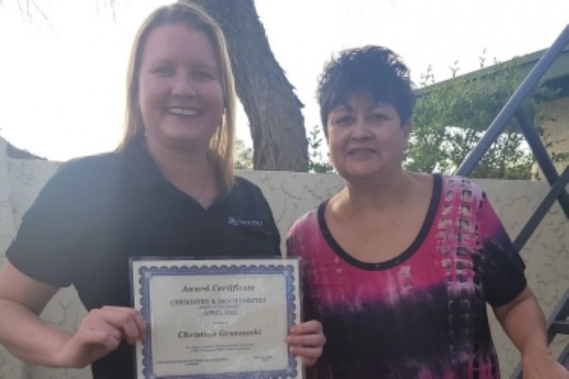 Christine and Olivia smiling with award