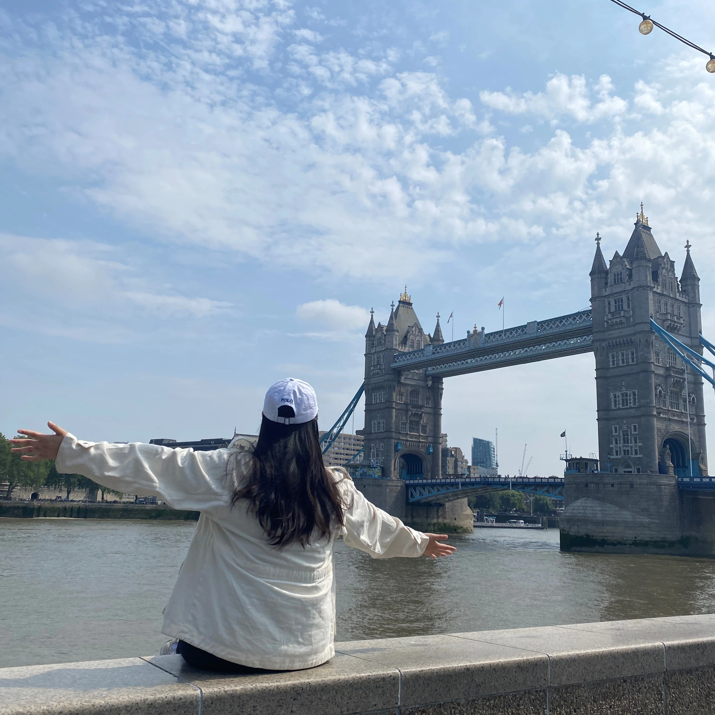 Chloe Park with back to camera facing a bridge with a historic looking building at either end