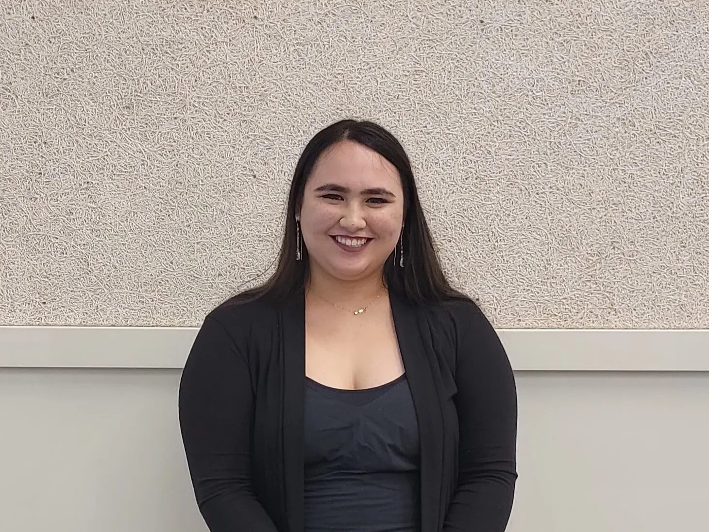 Lilia Alexis Koelemay smiling towards the camera, wearing black.