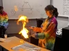 Alyssa Wood in a lab coat conducting an experiment with fire over a lab table